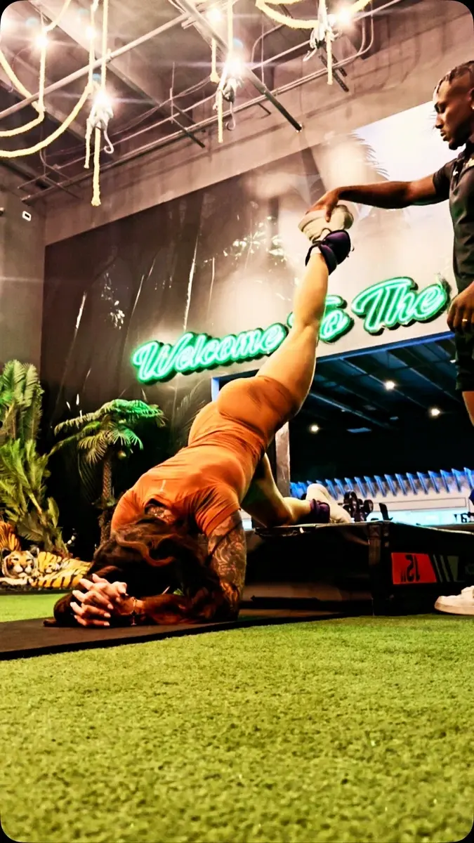 Rob guiding a client through an elevated leg exercise at the gym.