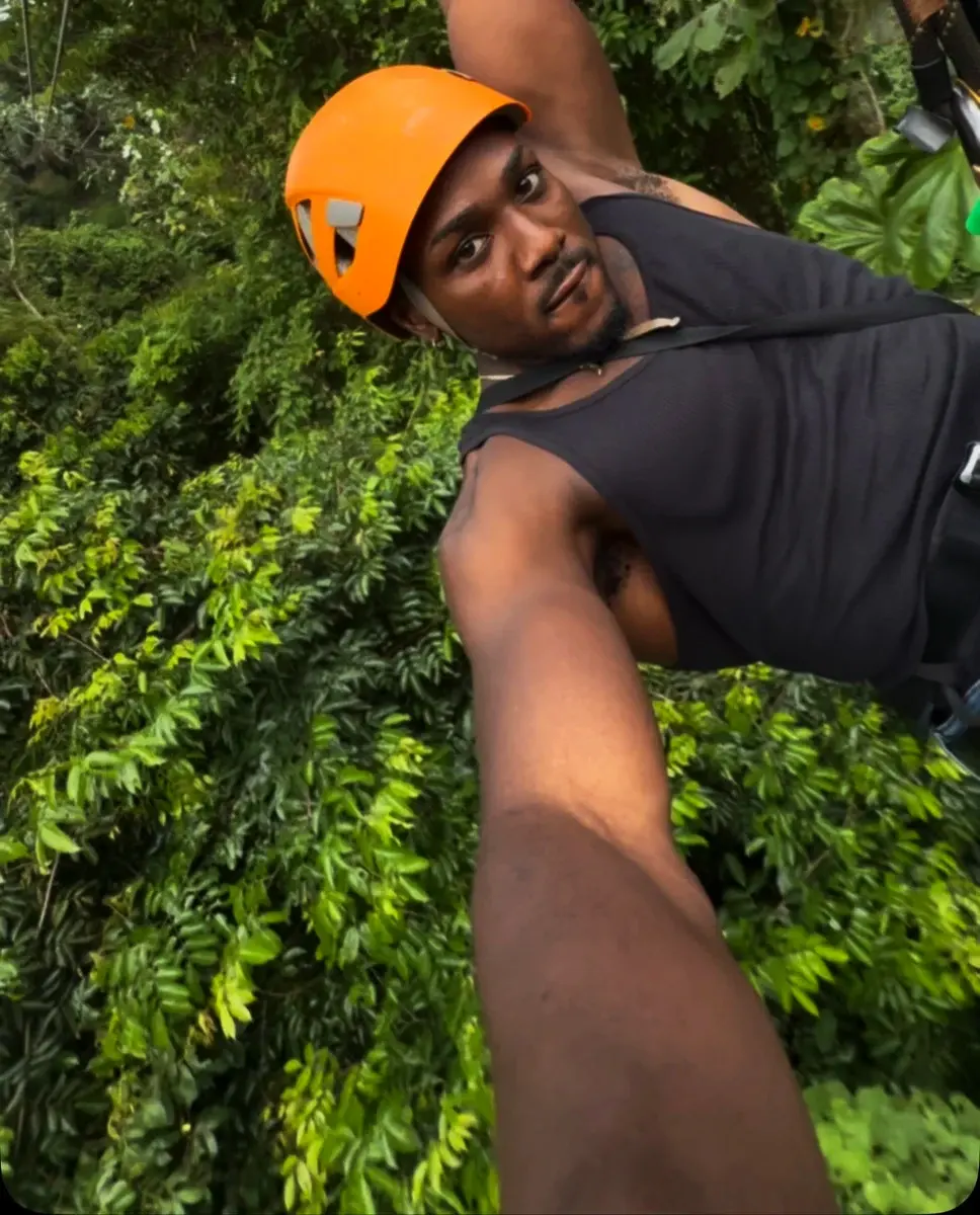 Rob wearing an orange helmet and harness during an outdoor adventure.