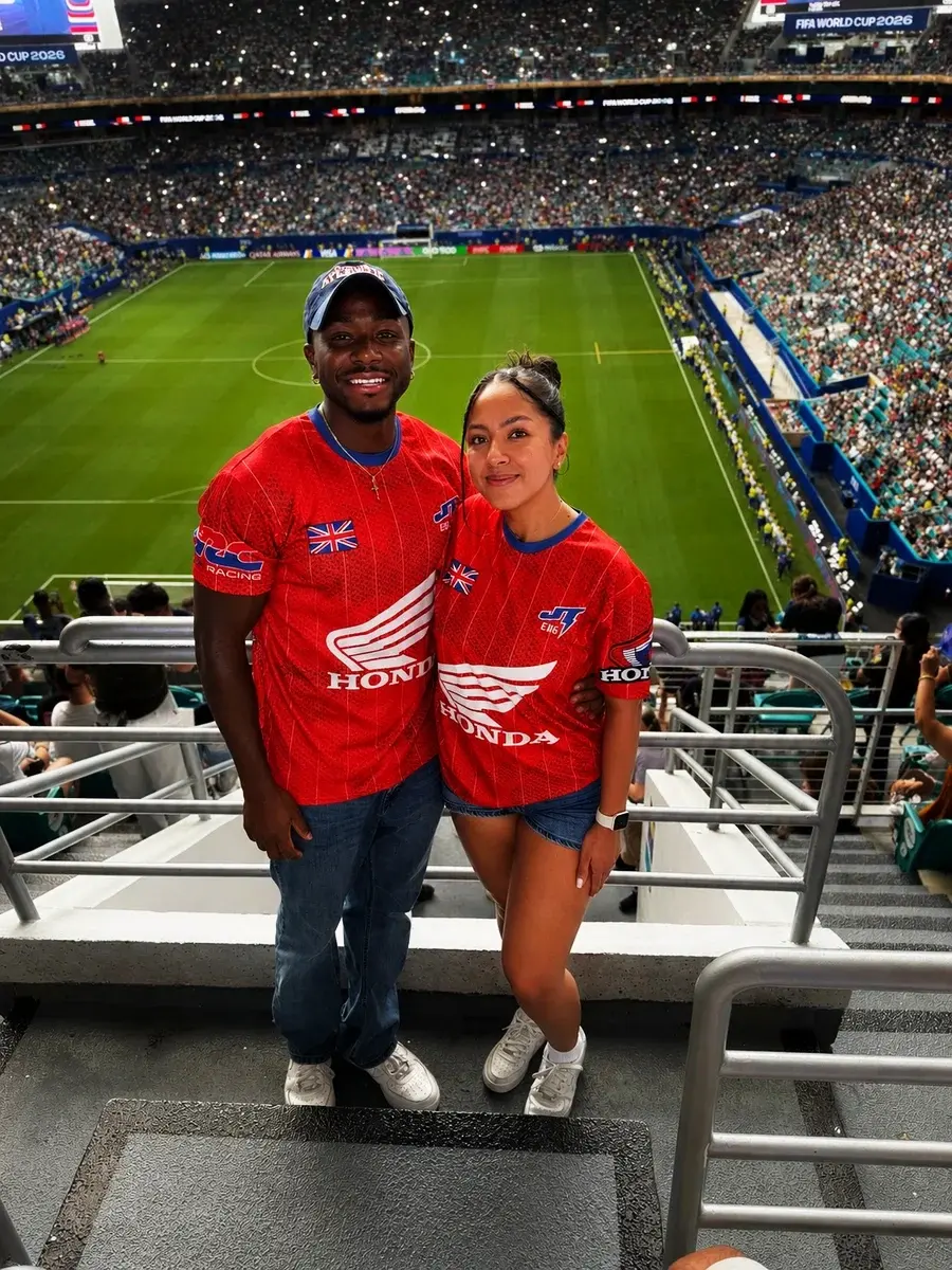 Rob and a companion smiling in the stands of a football stadium.