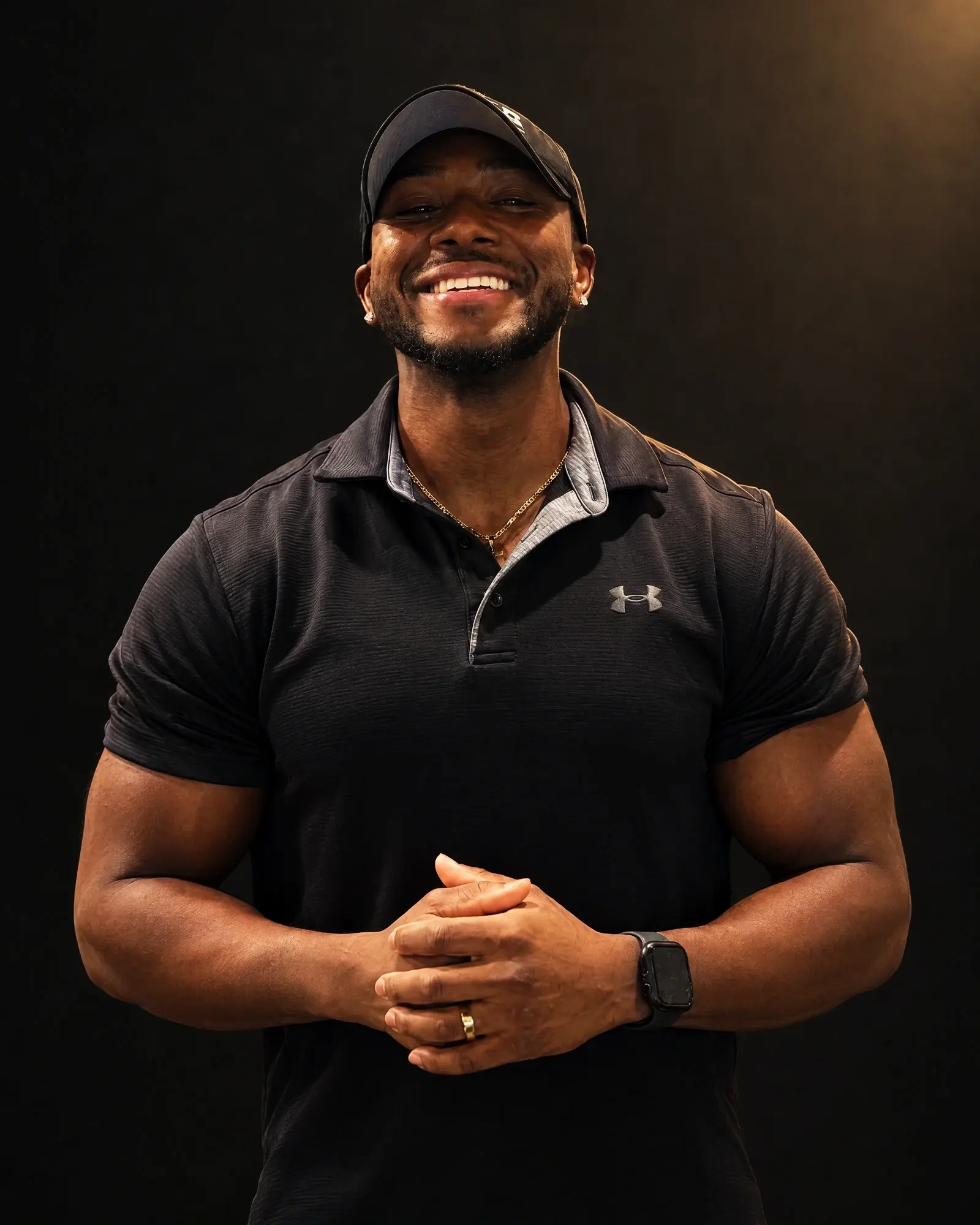Robert Beauduy smiling in a black cap and polo